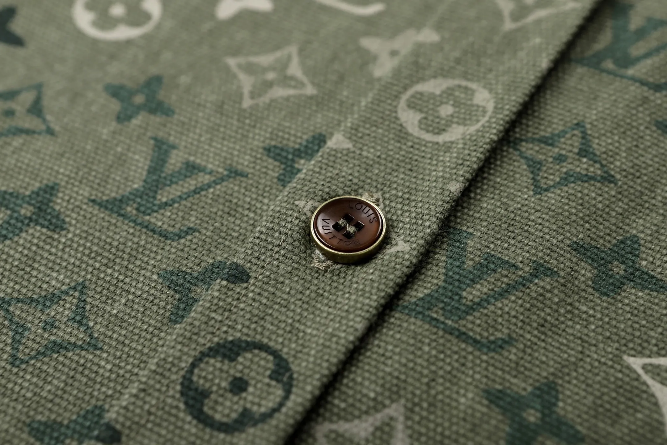🅿️600 1v 25SS full-print green camouflage work jacket style shirt. The original purchase was 16,000 and developed. The fabric is made of custom-dyed 50-count plain double-ply pique cotton. Before positioning and cutting the fabric pieces, digital typesetting is used to lock the position of the full-print Monogram pattern to ensure that the pattern is continuous and without misalignment after splicing. The pattern alignment error between the body and the solid color splicing area is controlled within 0.5cm. The printing process uses digital direct injection technology: the pigment penetrates the fabric fibers with micron-sized particles, presenting a low-saturation vintage tone while maintaining the breathability of the fabric. The wear resistance of the printing layer reaches level 5 (friction test ≥ 200 times without falling off). The body is made of twill canvas blended fabric, and the splicing parts are reinforced with double-needle buried clip technology. The buttons are made of brass-plated matte paint, and the stitching is made of high-tenacity nylon thread with a tensile strength of 150N. The overall process takes into account both visual integrity and practical durability. The overall wiring is straight and delicate, the fabric is comfortable and soft, and the color is consistent without color difference. It can be matched with the same style to create a fashionable look and control various occasions. Customized accessories, complete with three standards, the same style for men and women. Size:S-M-L-XL
